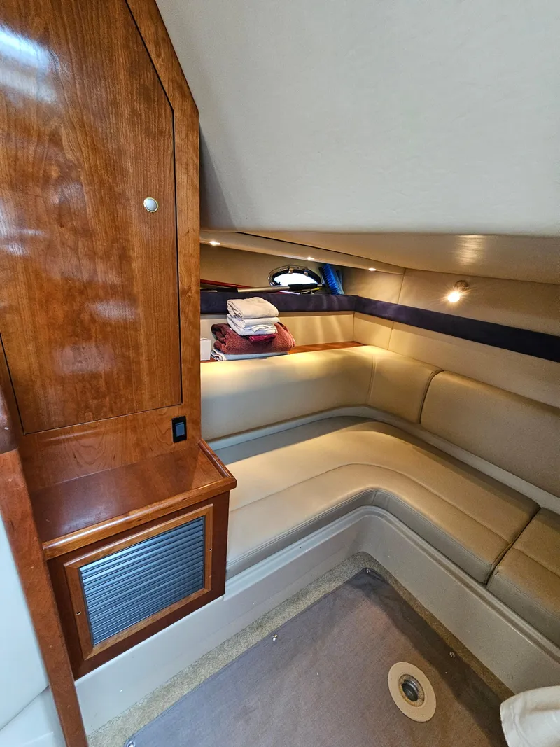 Slide: The Image of 2004 Cruisers Yachts 340 Express cabin interior with cozy seating and wooden cabinetry. - 40