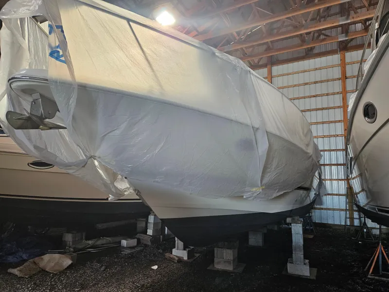 Slide: The Image of 2004 Cruisers Yachts 340 Express covered in storage, inside a boat shed. - 50