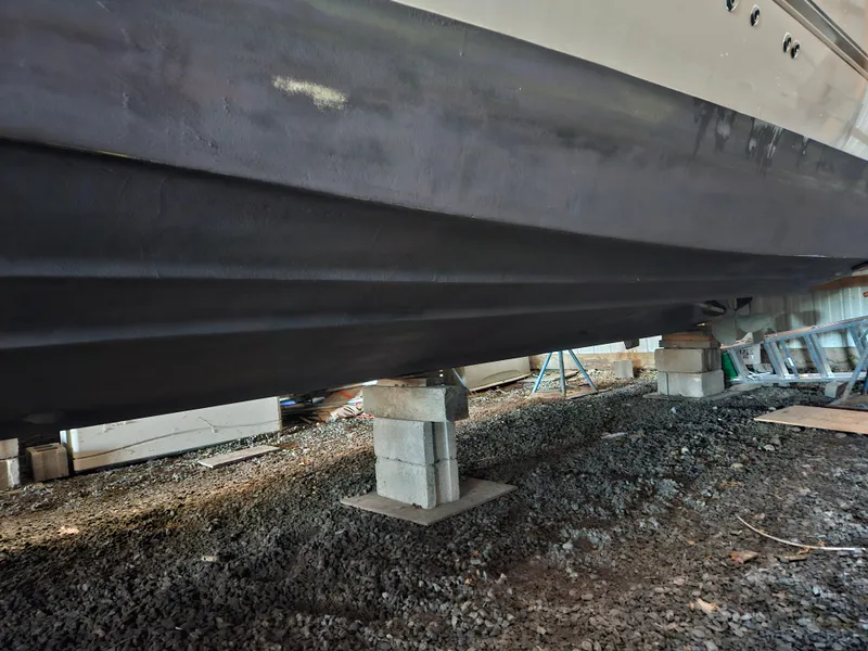 Slide: The Image of 2004 Cruisers Yachts 340 Express boat hull on blocks in a storage area. - 51