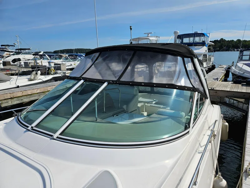 Slide: The Image of 2004 Cruisers Yachts 340 Express docked at marina, featuring sleek design and covered cockpit. - 6