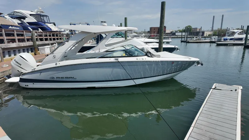 Slide: The Image of 2021 Regal LX6 boat docked in a marina, side view. - 1