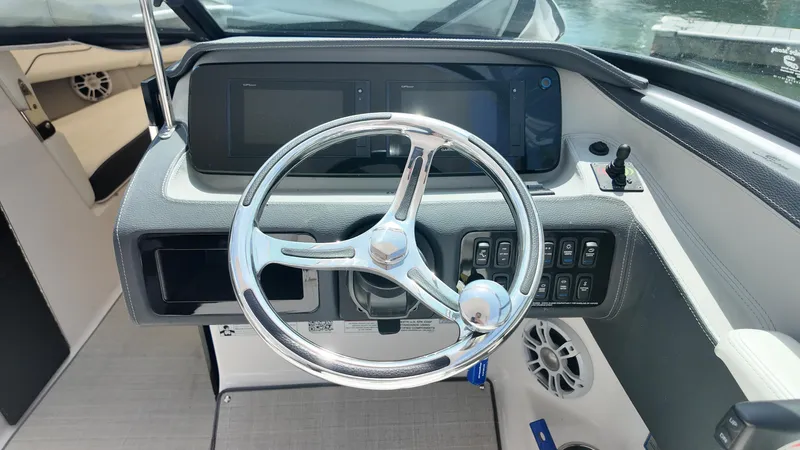 Slide: The Image of 2021 Regal LX6 boat dashboard with steering wheel and control panel. - 12