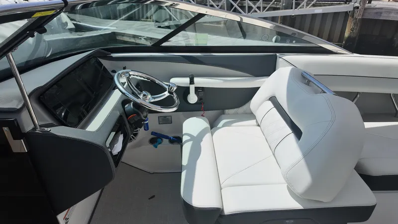 Slide: The Image of 2021 Regal LX6 boat interior with sleek steering wheel and white seating. - 13