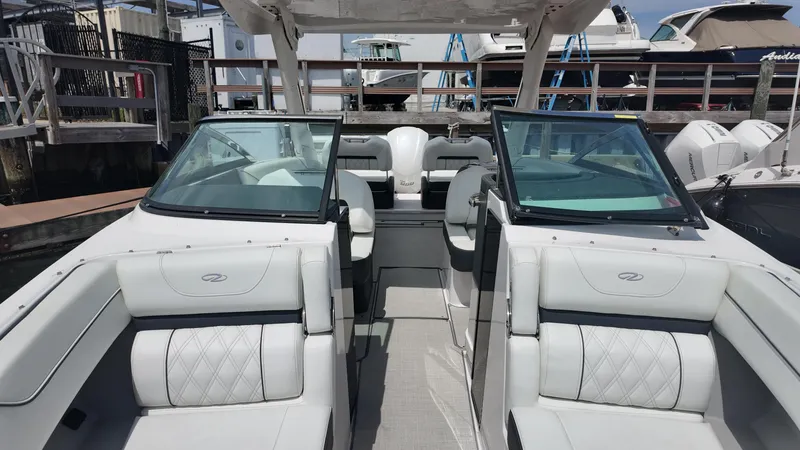 Slide: The Image of 2021 Regal LX6 boat interior with white seating and open windshield at a marina. - 17