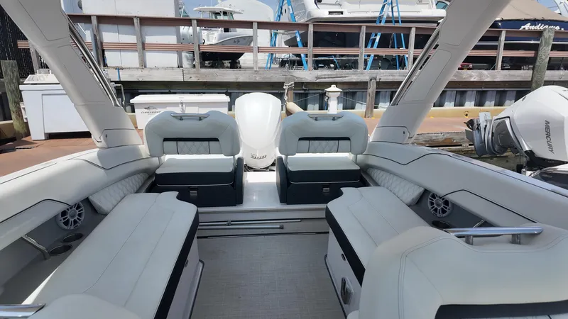 Slide: The Image of 2021 Regal LX6 boat interior with white seating and modern design at a dock. - 9