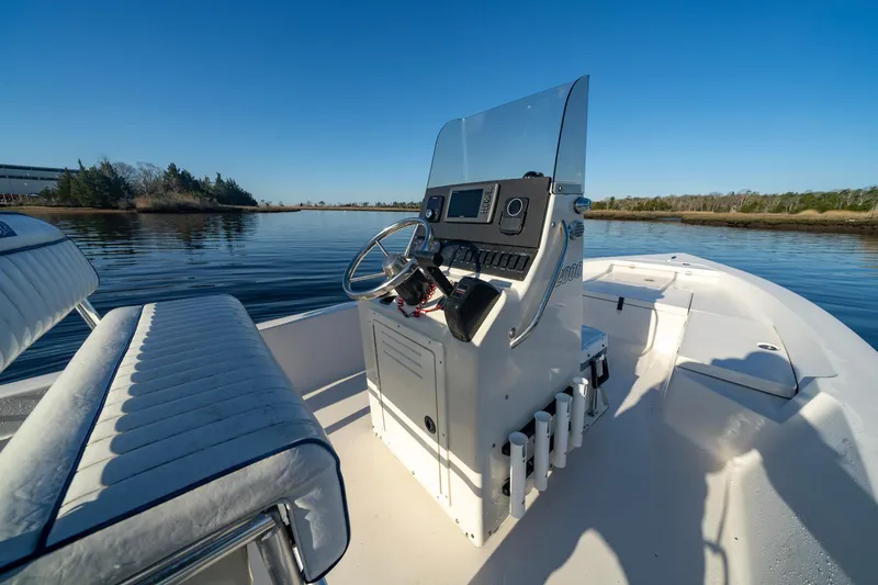 Slide: The Image of Pathfinder 2000v boat interior, 2005 model, featuring steering console and seating on calm water. - 5