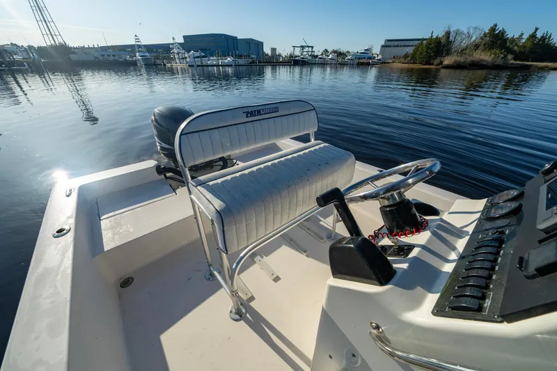Slide: The Image of 2005 Pathfinder 2000v boat interior with steering wheel and seating, docked on calm water. - 6