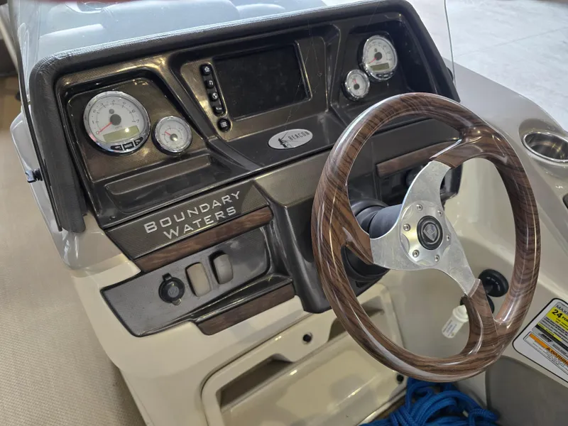Slide: The Image of 2014 Premier 275 Boundary Waters boat dashboard with wood-grain steering wheel and gauges. - 15
