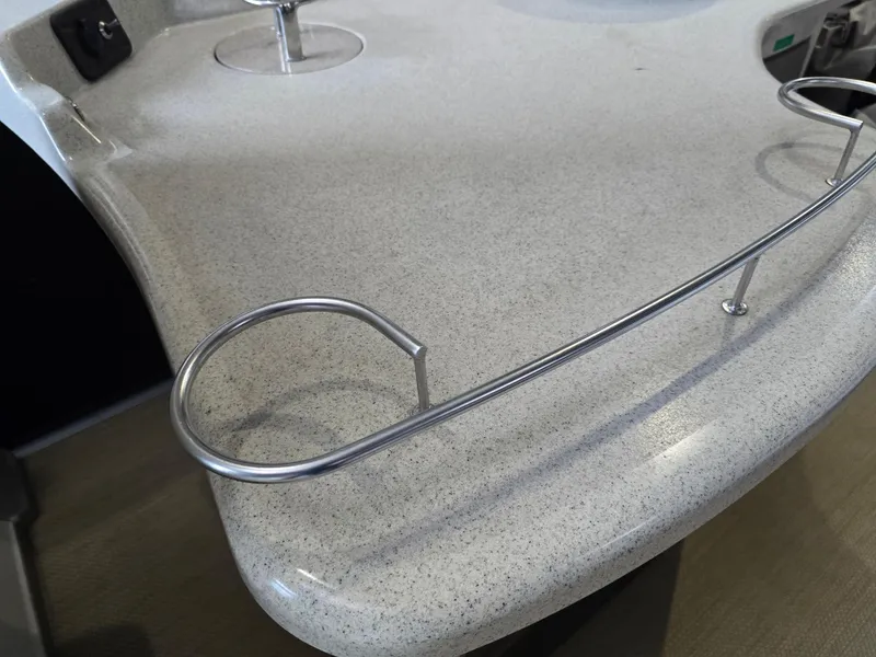 Slide: The Image of Premier 275 Boundary Waters 2014 boat countertop with metal railing and cup holder. - 19