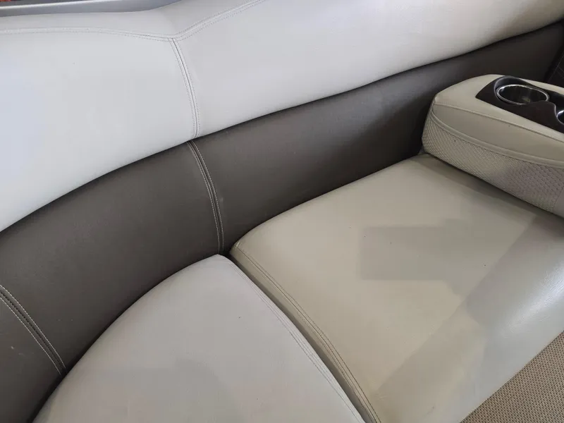 Slide: The Image of Premier 275 Boundary Waters 2014 boat interior seating with cup holders, featuring beige and gray upholstery. - 28