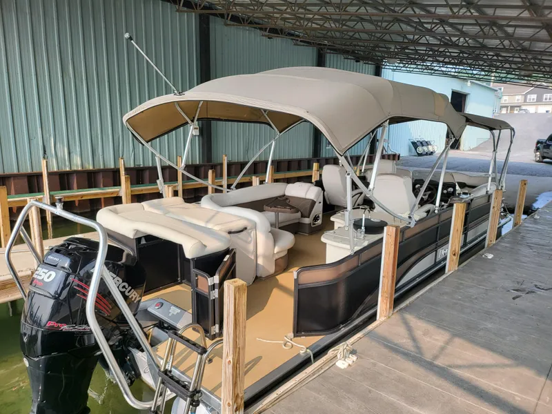 Slide: The Image of 2014 Premier 275 Boundary Waters pontoon boat docked under a covered structure. - 3