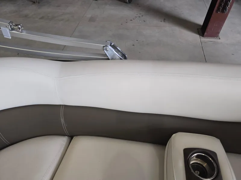 Slide: The Image of 2014 Premier 275 Boundary Waters boat interior with beige seating and cup holder. - 36