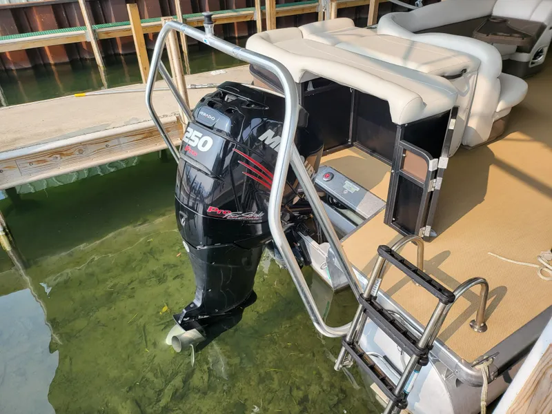 Slide: The Image of 2014 Premier 275 Boundary Waters pontoon boat with Mercury 250 outboard motor, docked in clear water. - 4
