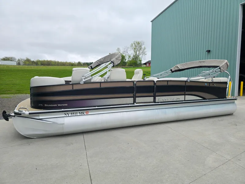 Slide: The Image of 2014 Premier 275 Boundary Waters pontoon boat parked near a green building. - 48
