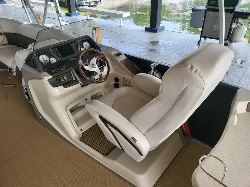 Slide: The Image of Captain's chair and dashboard of a 2014 Premier 275 Boundary Waters pontoon boat. - 7
