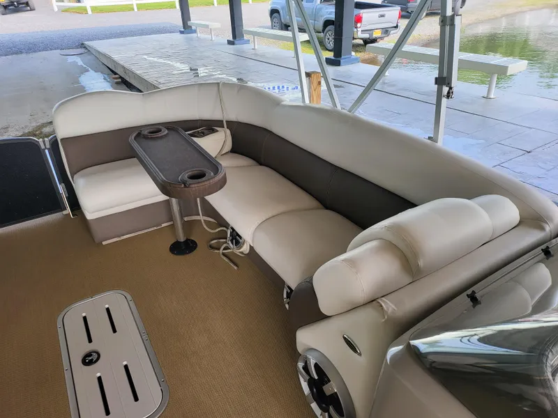 Slide: The Image of 2014 Premier 275 Boundary Waters pontoon boat interior with beige seating and table. - 8