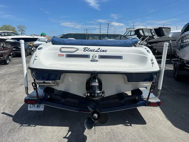 Slide: The Image of 2002 Crownline 180 BR boat, rear view, parked in marina with other boats. - 10