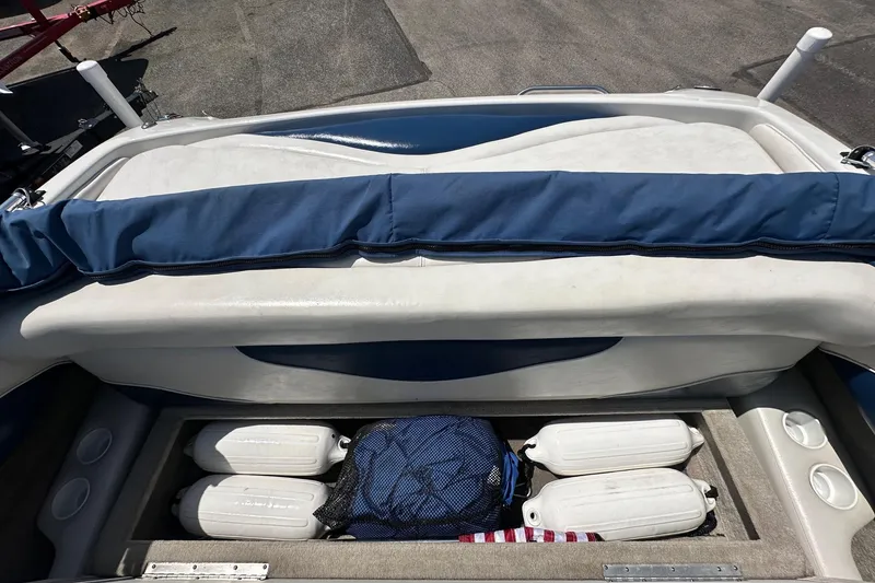 Slide: The Image of 2002 Crownline 180 BR boat interior with storage compartment and fenders. - 12