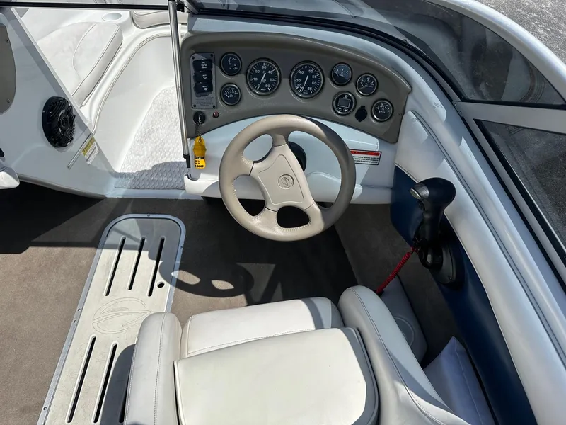 Slide: The Image of 2002 Crownline 180 BR boat interior with steering wheel and dashboard controls. - 7