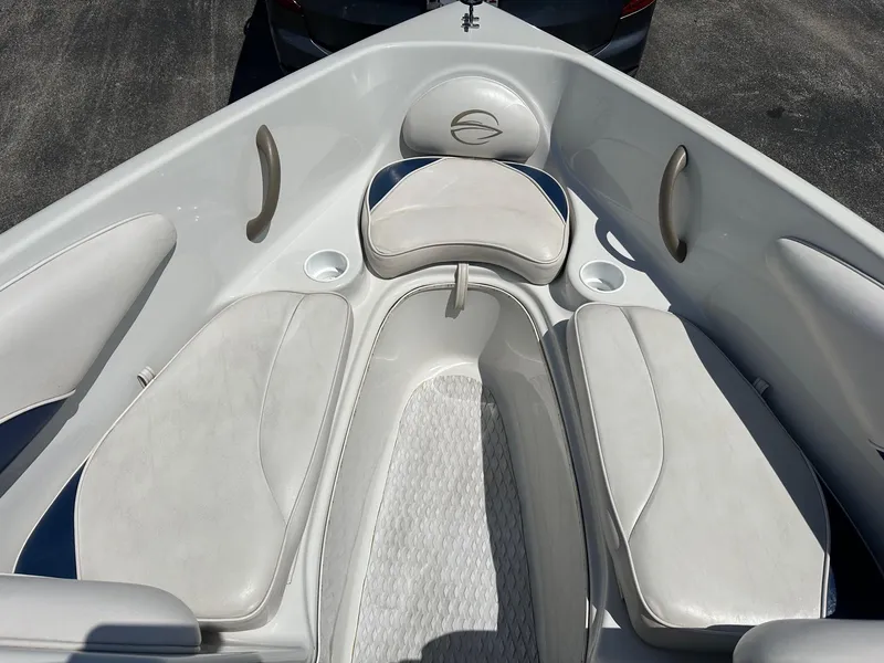 Slide: The Image of 2002 Crownline 180 BR boat interior with white cushioned seating and cup holders. - 8
