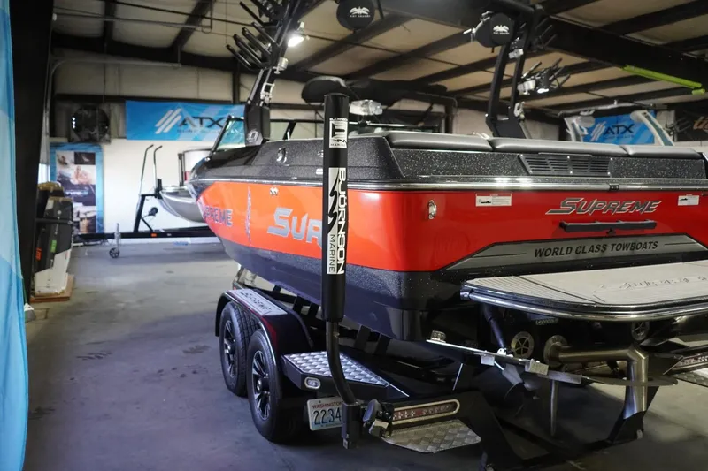 Slide: The Image of 2017 Supreme S211 boat in a showroom, showcasing sleek design and vibrant orange color. - 12