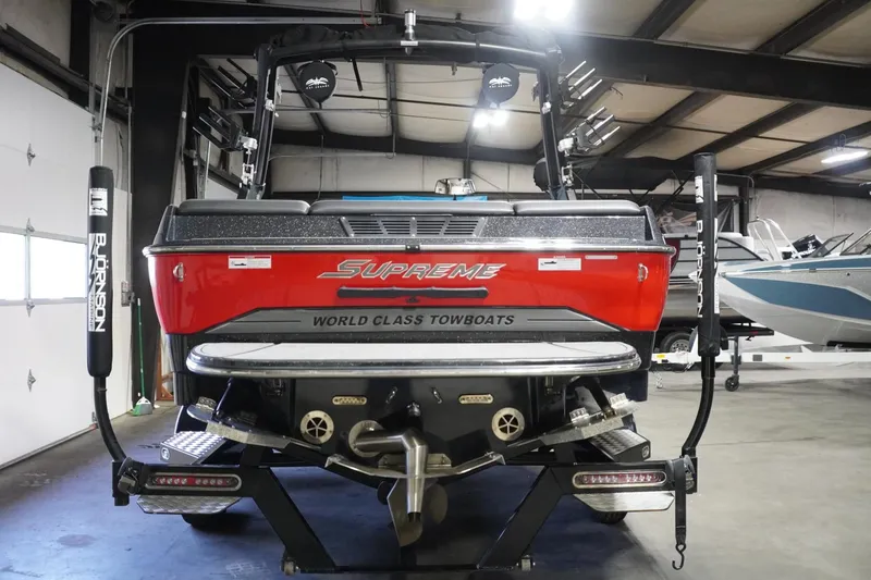 Slide: The Image of 2017 Supreme S211 towboat in a garage, showcasing rear design and branding. - 13