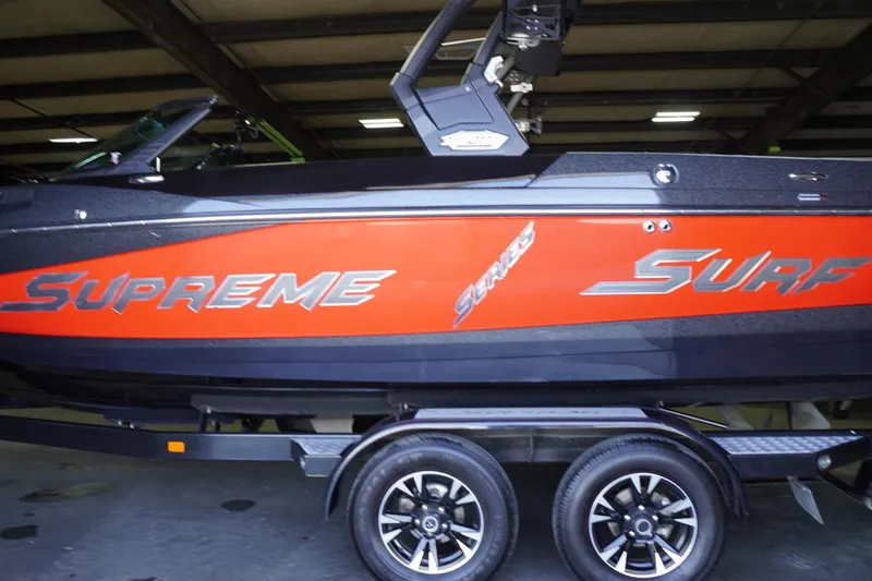 Slide: The Image of 2017 Supreme S211 boat with red and black design on a trailer in a garage. - 19