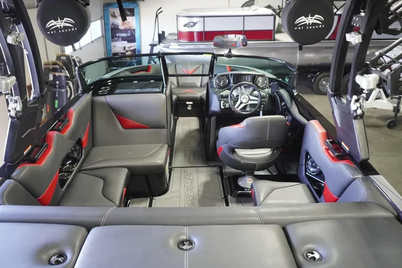 Slide: The Image of 2017 Supreme S211 boat interior with gray and red seating, modern dashboard, and spacious layout. - 22
