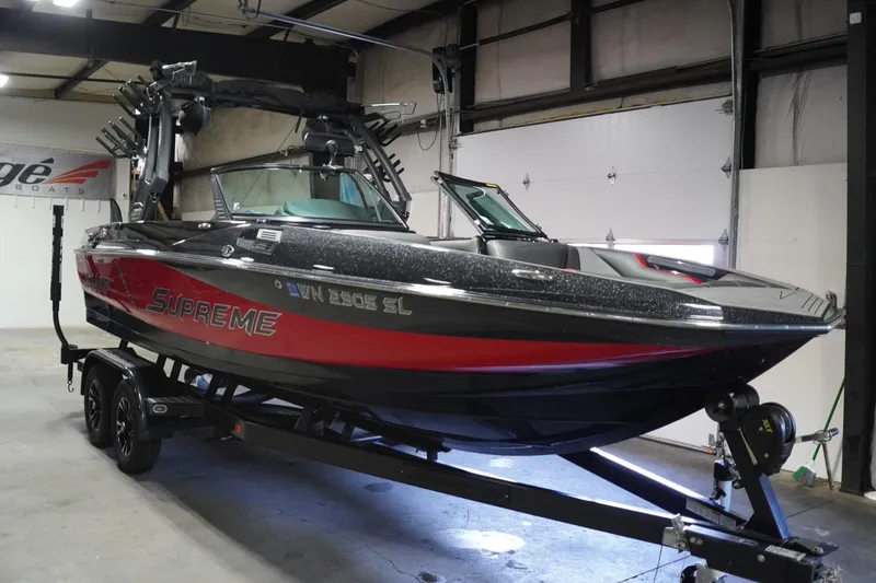 Slide: The Image of 2017 Supreme S211 boat in a garage, black and red design, on a trailer. - 3