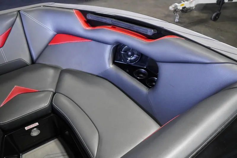 Slide: The Image of 2017 Supreme S211 boat interior with gray and red upholstery, featuring a speaker and cup holders. - 35