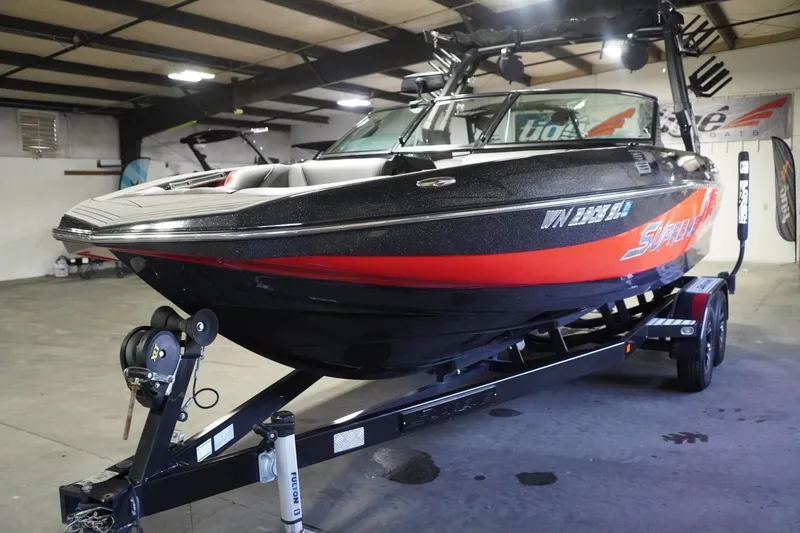 Slide: The Image of 2017 Supreme S211 boat in a garage, black and red design on a trailer. - 5