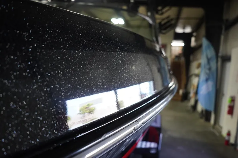 Slide: The Image of 2017 Supreme S211 boat with sleek, glossy black finish in a showroom. - 6