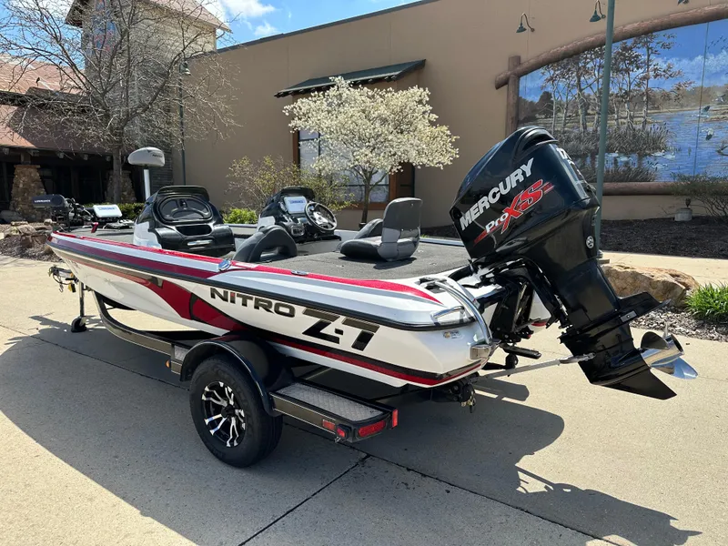 Slide: The Image of 2015 Nitro Z7 DC boat with Mercury engine, parked outdoors on a sunny day. - 2