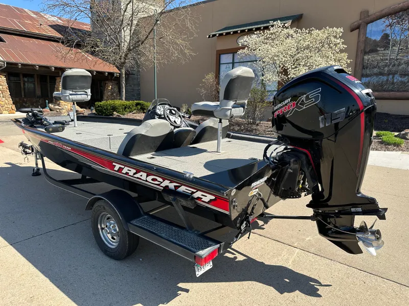 Slide: The Image of 2018 Tracker Pro Team 190 TX fishing boat with motor, parked outdoors. - 2