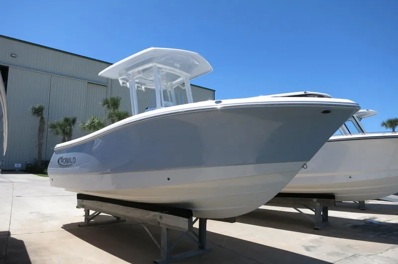 Slide: The Image of 2025 Robalo R230 Center Console boat displayed outdoors on a sunny day. - 0