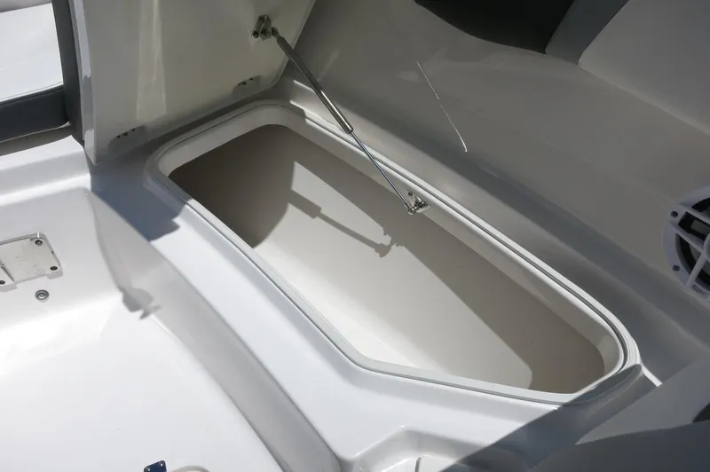 Slide: The Image of 2025 Robalo R230 Center Console storage compartment, open lid, white interior. - 12