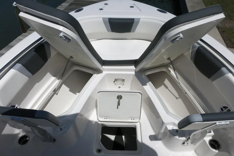 Slide: The Image of 2025 Robalo R230 Center Console boat with open storage compartments and seating area. - 14