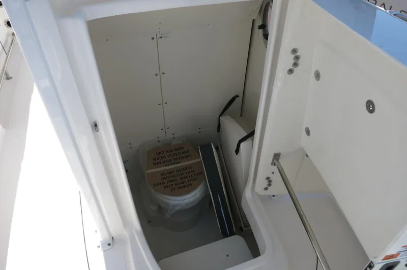 Slide: The Image of 2025 Robalo R230 Center Console boat interior with compact marine toilet. - 16