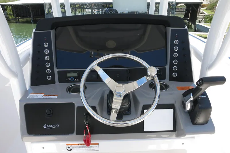 Slide: The Image of 2025 Robalo R230 Center Console boat dashboard with steering wheel and controls. - 23