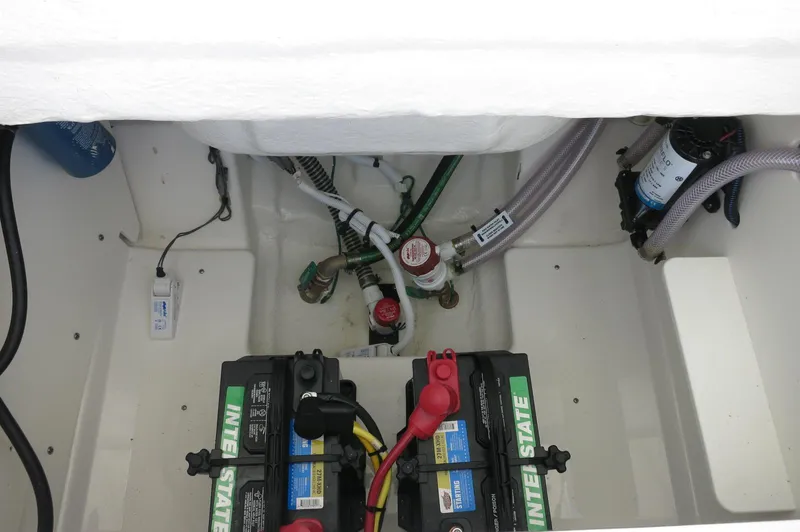 Slide: The Image of 2025 Robalo R230 Center Console boat battery compartment with wiring and components. - 28