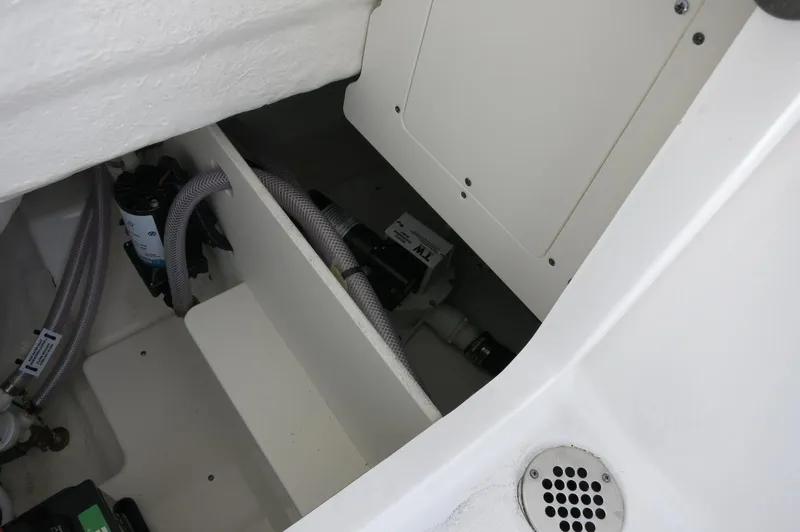 Slide: The Image of 2025 Robalo R230 Center Console boat interior, showcasing storage and mechanical components. - 29