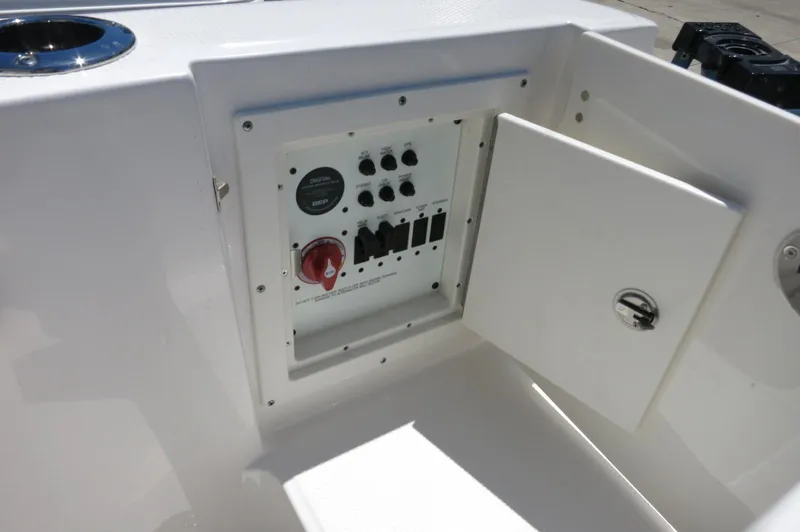 Slide: The Image of 2025 Robalo R230 Center Console boat control panel with open compartment. - 31