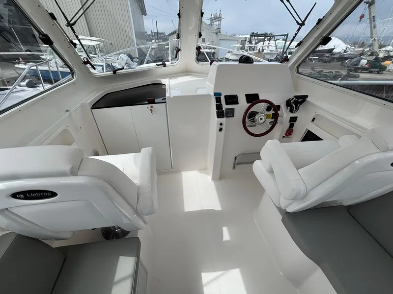 Slide: The Image of 2025 NorthCoast 315 HT boat interior with modern helm and seating. - 12