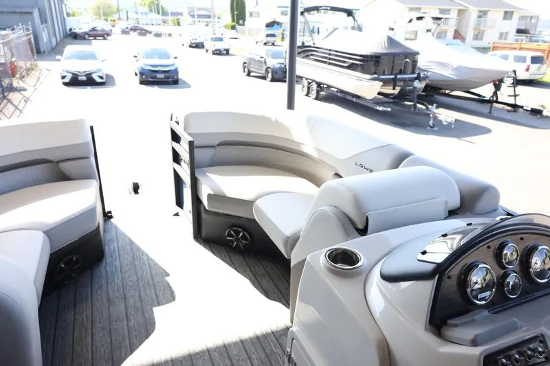 Slide: The Image of 2025 Lowe SS 210 DL pontoon boat interior with plush seating and modern dashboard. - 22