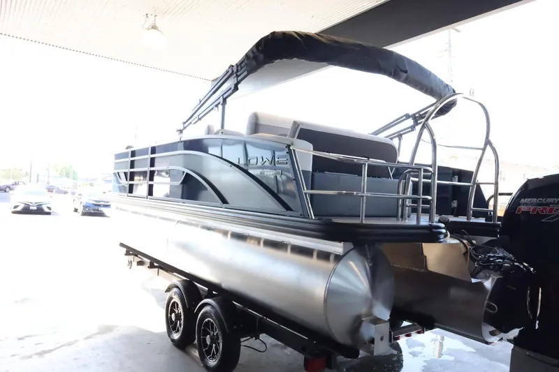 Slide: The Image of 2025 Lowe SS 210 DL pontoon boat on trailer in a covered area. - 6