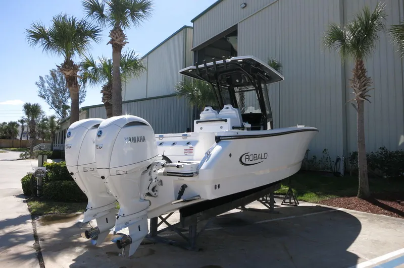 Slide: The Image of 2025 Robalo R250 Center Console boat with twin Yamaha engines, parked outdoors. - 10