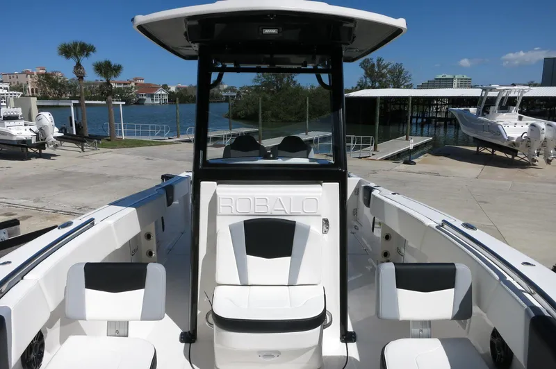 Slide: The Image of 2025 Robalo R250 Center Console boat docked near waterfront with clear blue sky. - 22