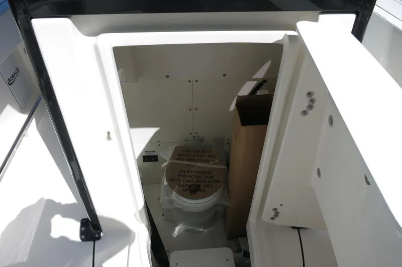 Slide: The Image of 2025 Robalo R250 Center Console boat interior with compact marine toilet. - 23
