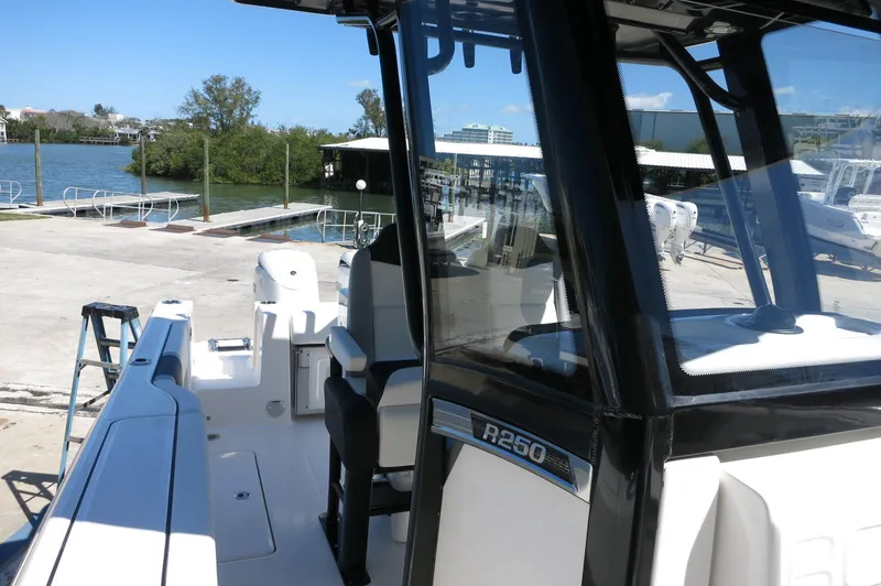 Slide: The Image of 2025 Robalo R250 Center Console boat docked near a waterfront. - 26