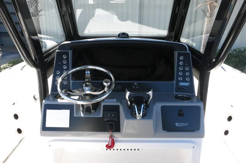 Slide: The Image of 2025 Robalo R250 Center Console boat dashboard with steering wheel and controls. - 33
